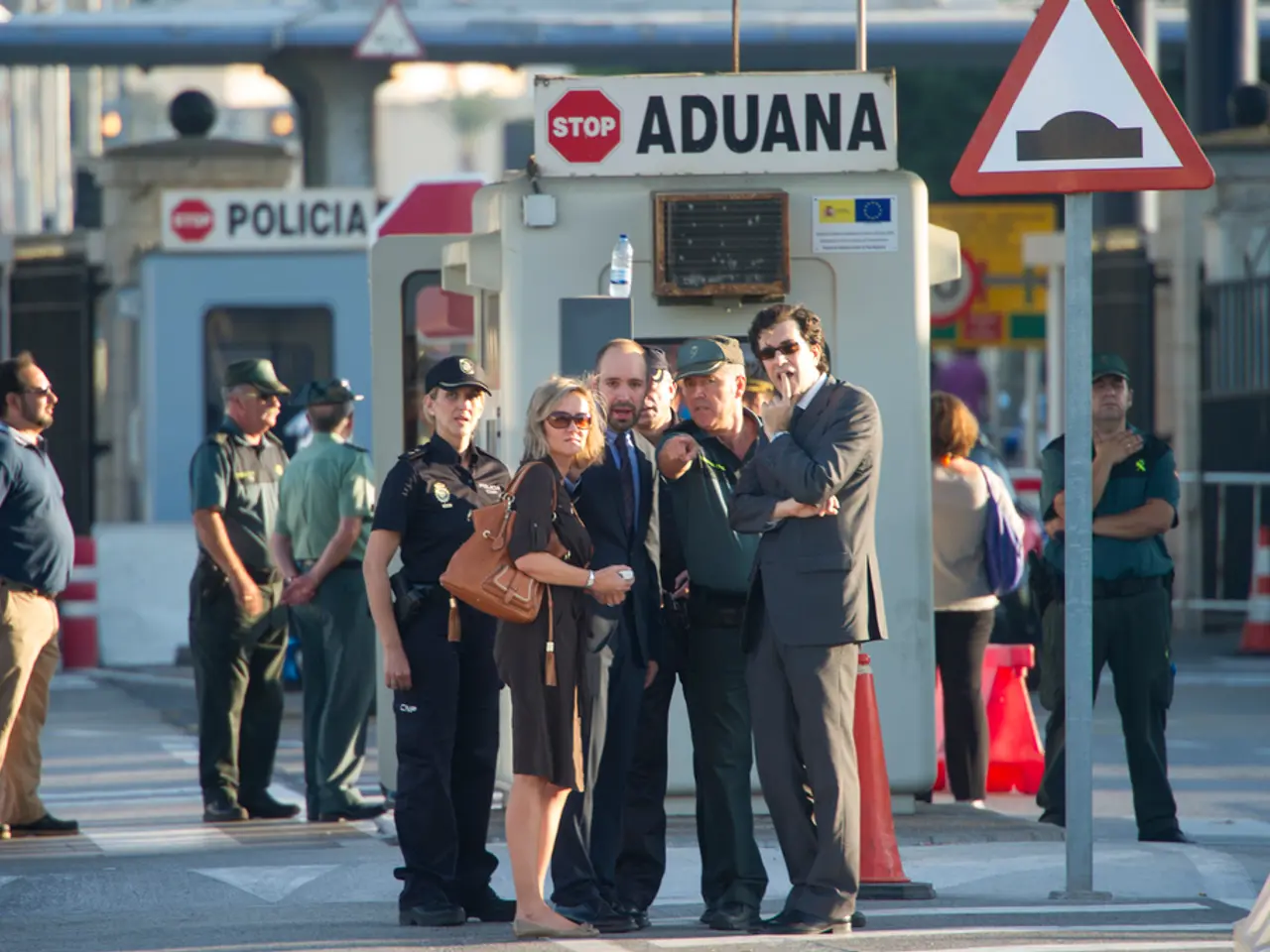 This picture describes about group of people, few people wore caps, behind them we can see...