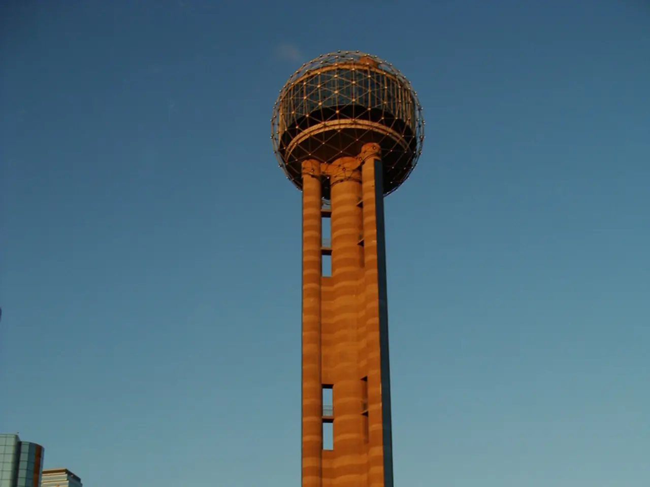 There is a tower and beside the tower there is a big building and in front of the building there...