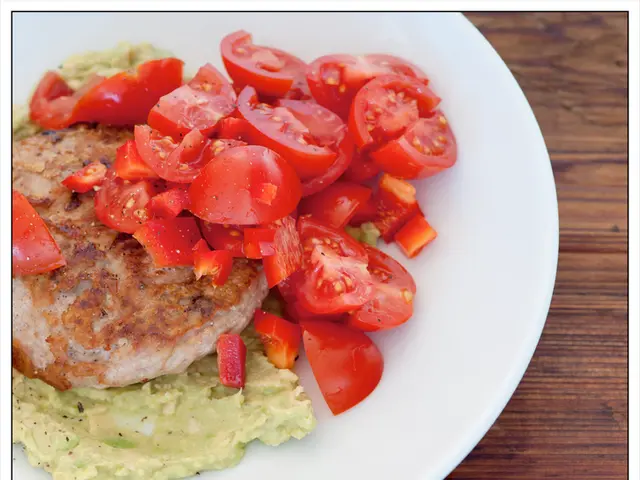 There are tomato pieces and other food items in a white color plate.