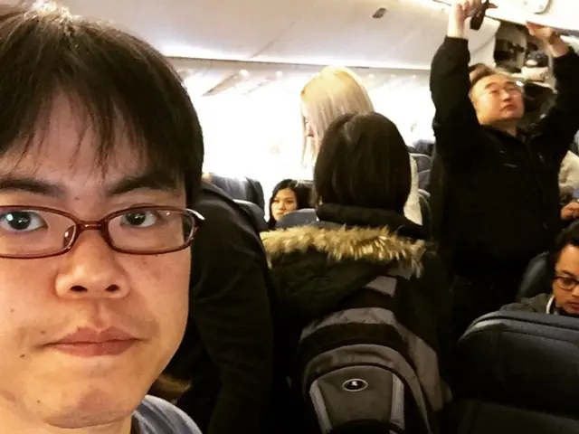 This image is taken inside an airplane. In this image there is a man on the left side. Beside him...