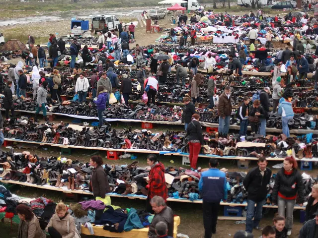 This image is taken in the market. In this image there are many people. We can see shoes, clothes...